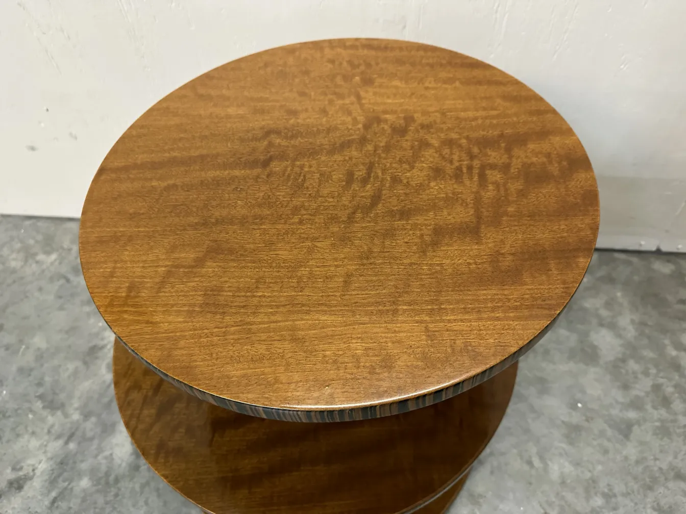 Petite table ancienne ronde, aux teintes brunes, ajoute de l'élégance à la décoration.