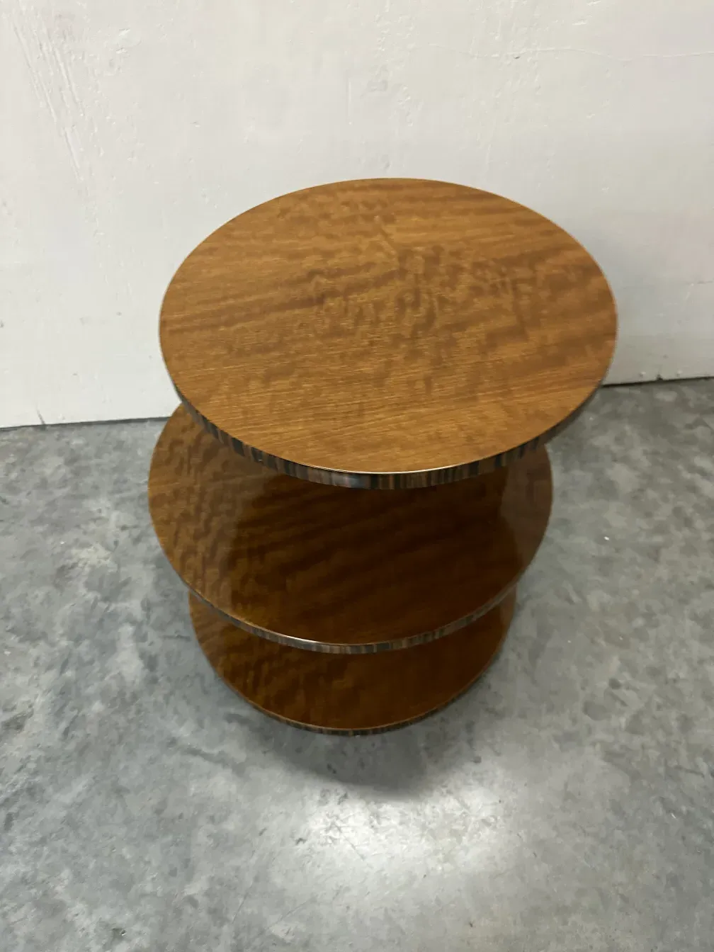 Mesinha antiga redonda com um design suave, colocada em um ambiente moderno.