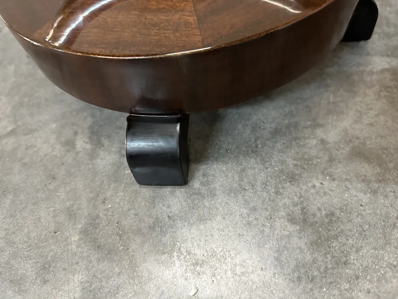 Mesinha antiga com pernas arqueadas em um ambiente discreto.