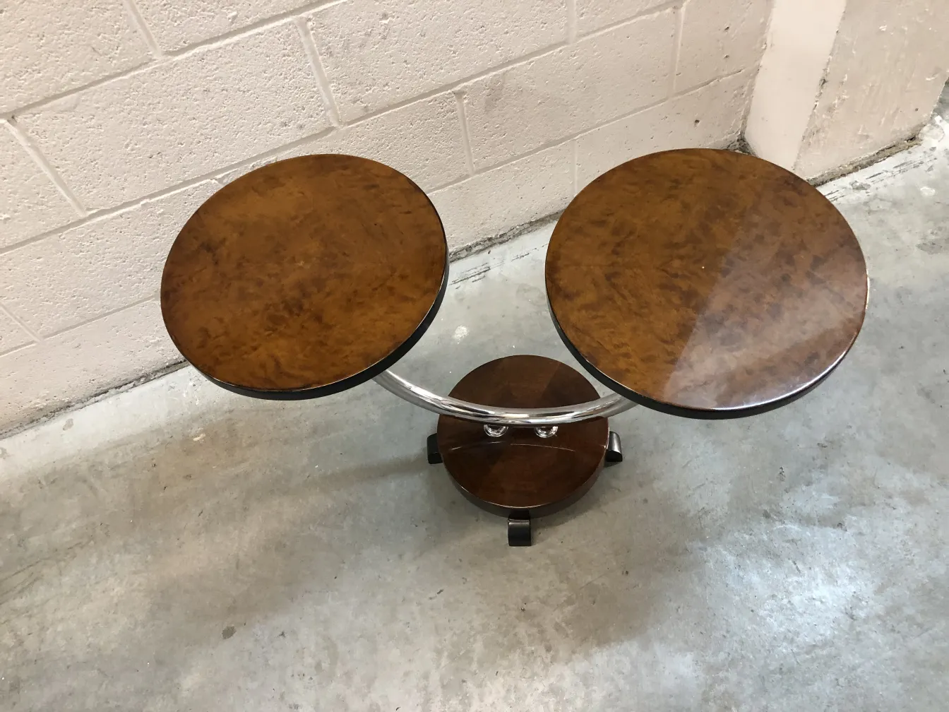 Mesita antigüedad con diseño moderno, dos superficies circulares en un entorno industrial.