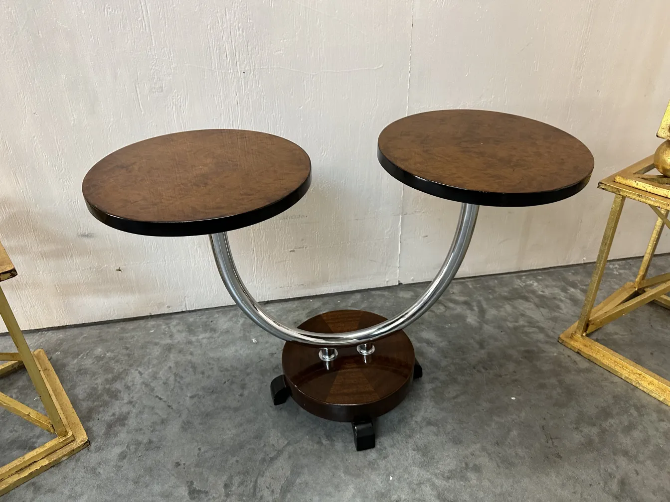 Small antique table with two round tops and a curved base. Antique atmosphere.