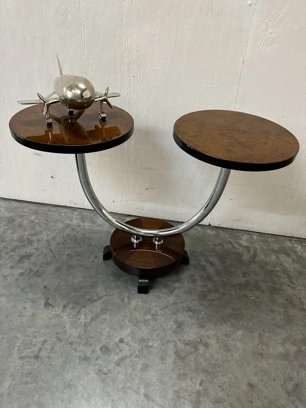 Mesinha antiga com dois tampos redondos e base cromada.