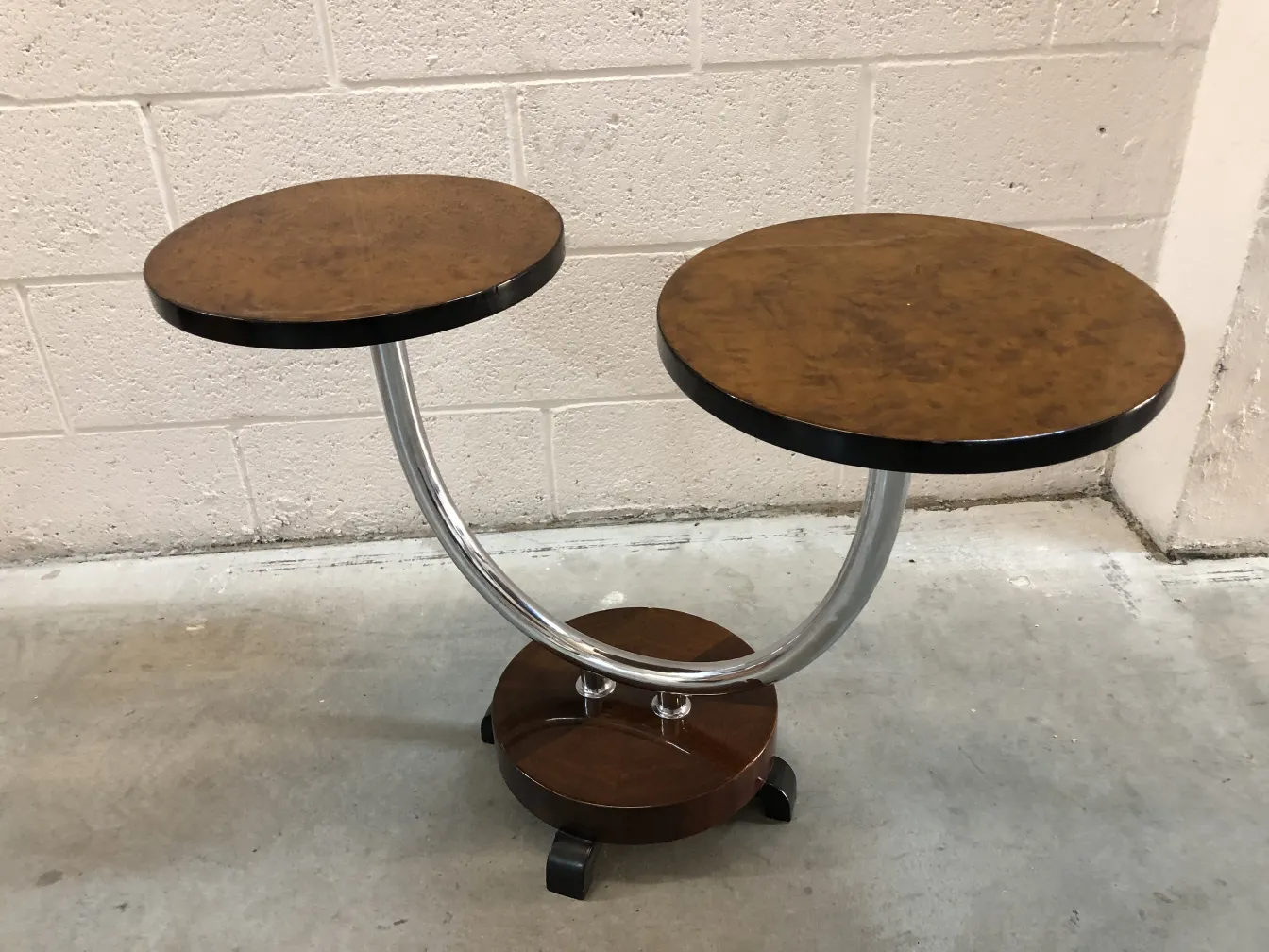 Antique small table with two levels and curved base against a plain background.