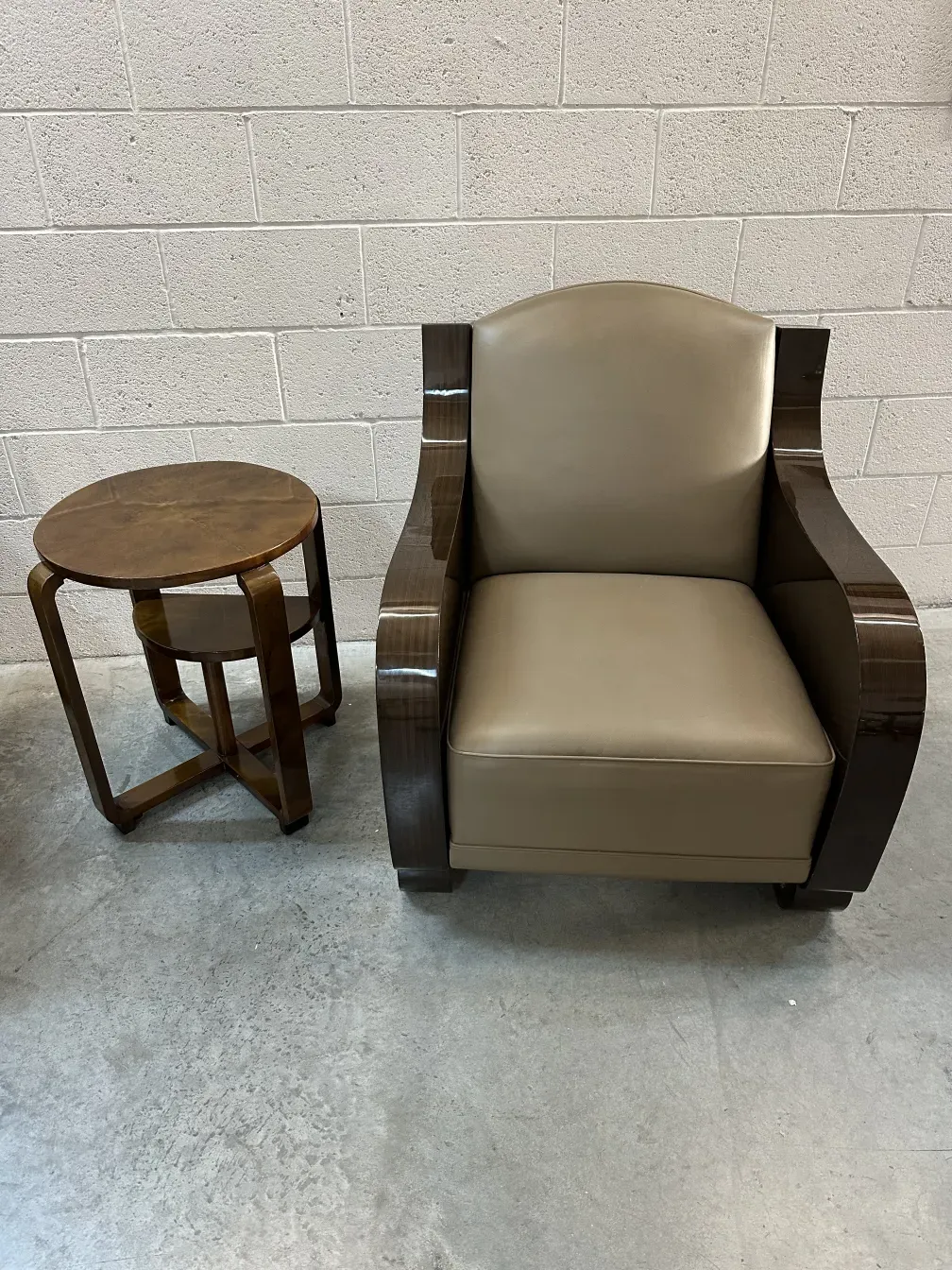 antigua mesita pequeña junto a un sillón en un ambiente moderno