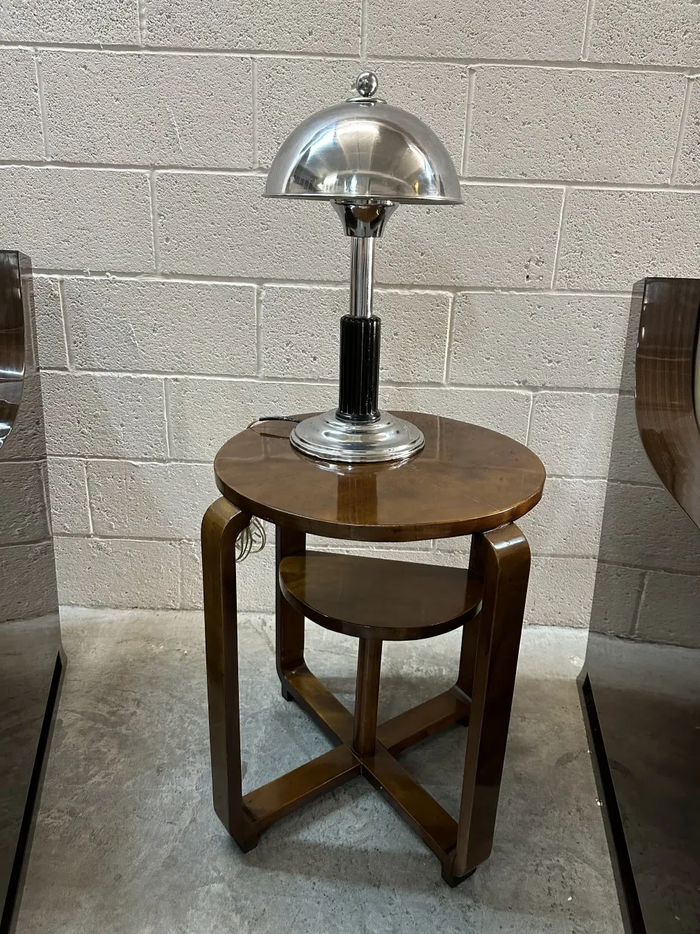 Small antique table with a silver lamp and black base in a modern setting