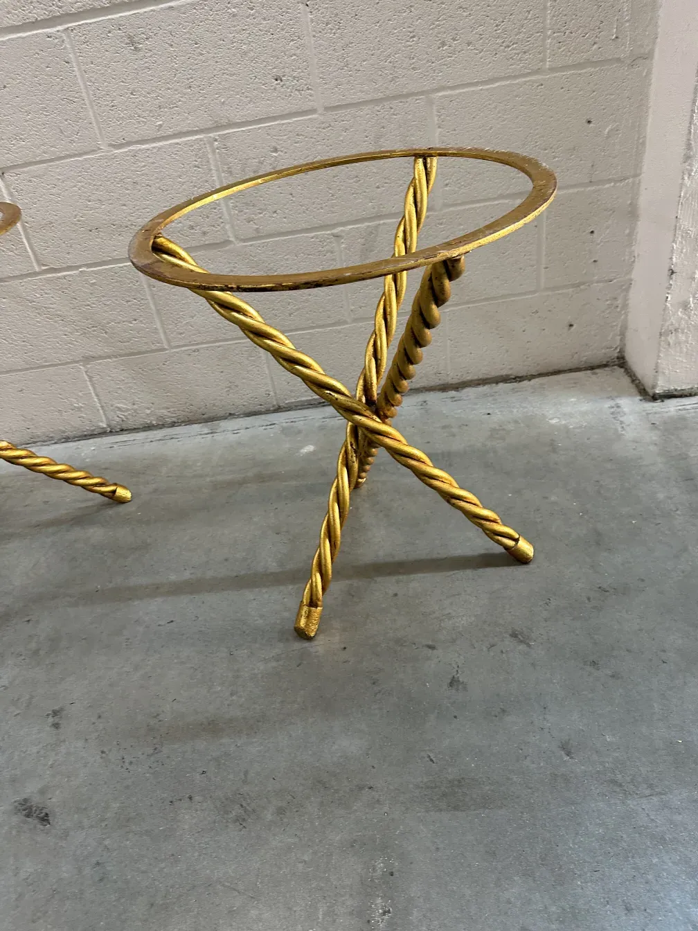 2 petites tables anciennes avec un design décoratif dans un cadre neutre