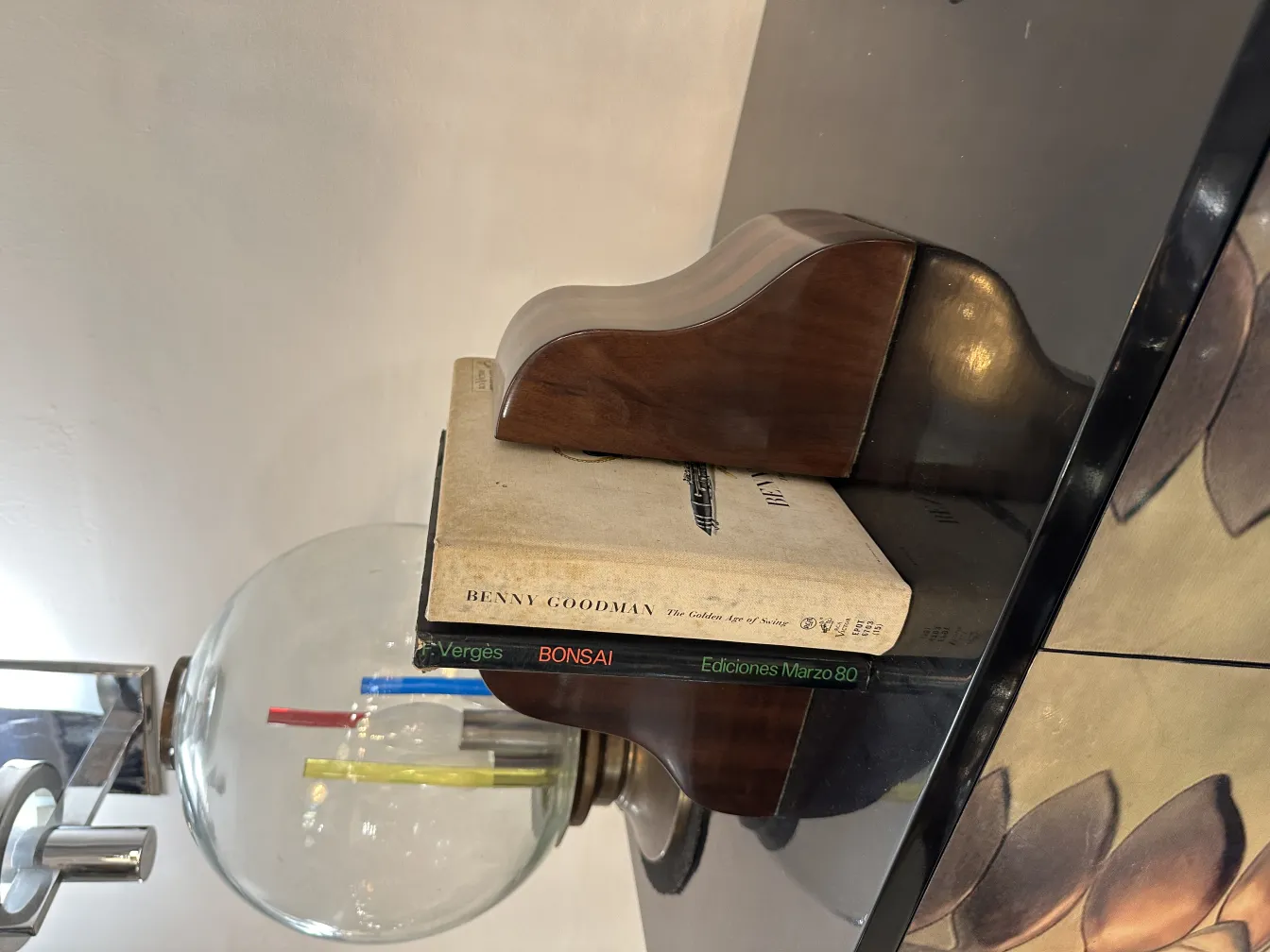 Старинные подставки для книг на фоне с книгами и декоративной лампой.