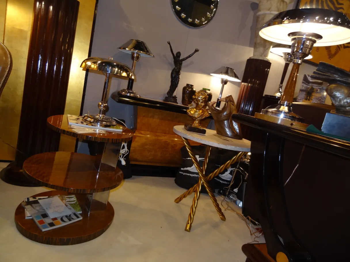 Dos mesitas antiguas en un ambiente decorativo con lámparas y esculturas