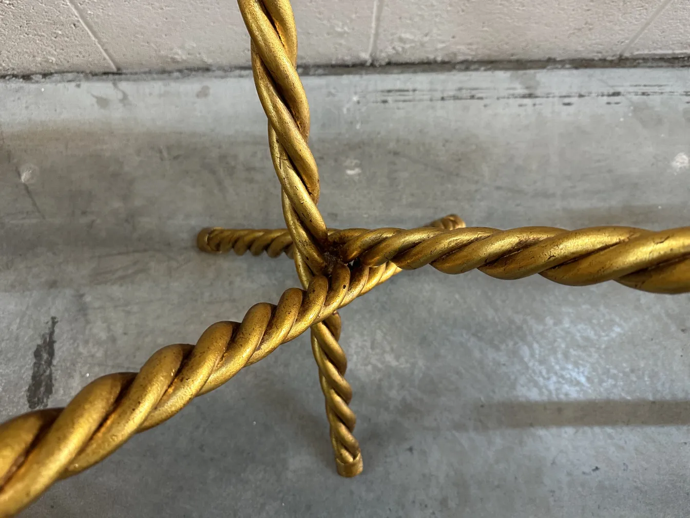 View of the legs of 2 antique small tables with twisted design, set against a grey background.
