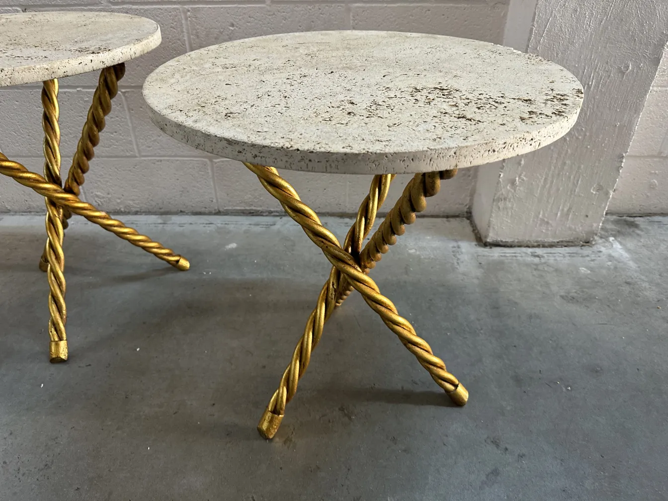 Two antique small tables with round surface and golden legs, elegant ambiance