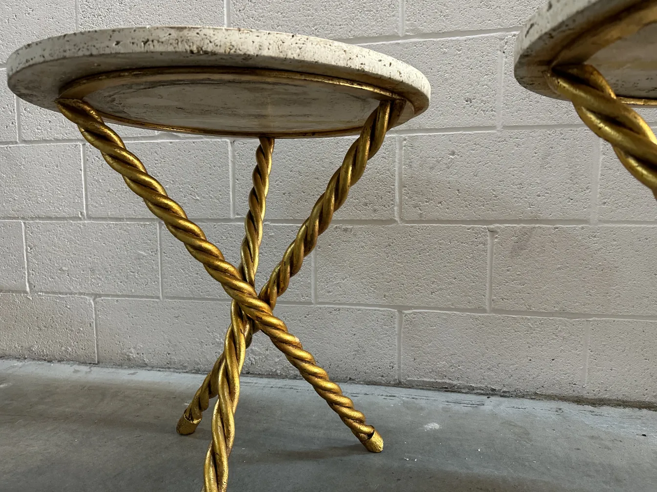 Deux petites tables anciennes avec des pieds dorés dans un cadre détendu.