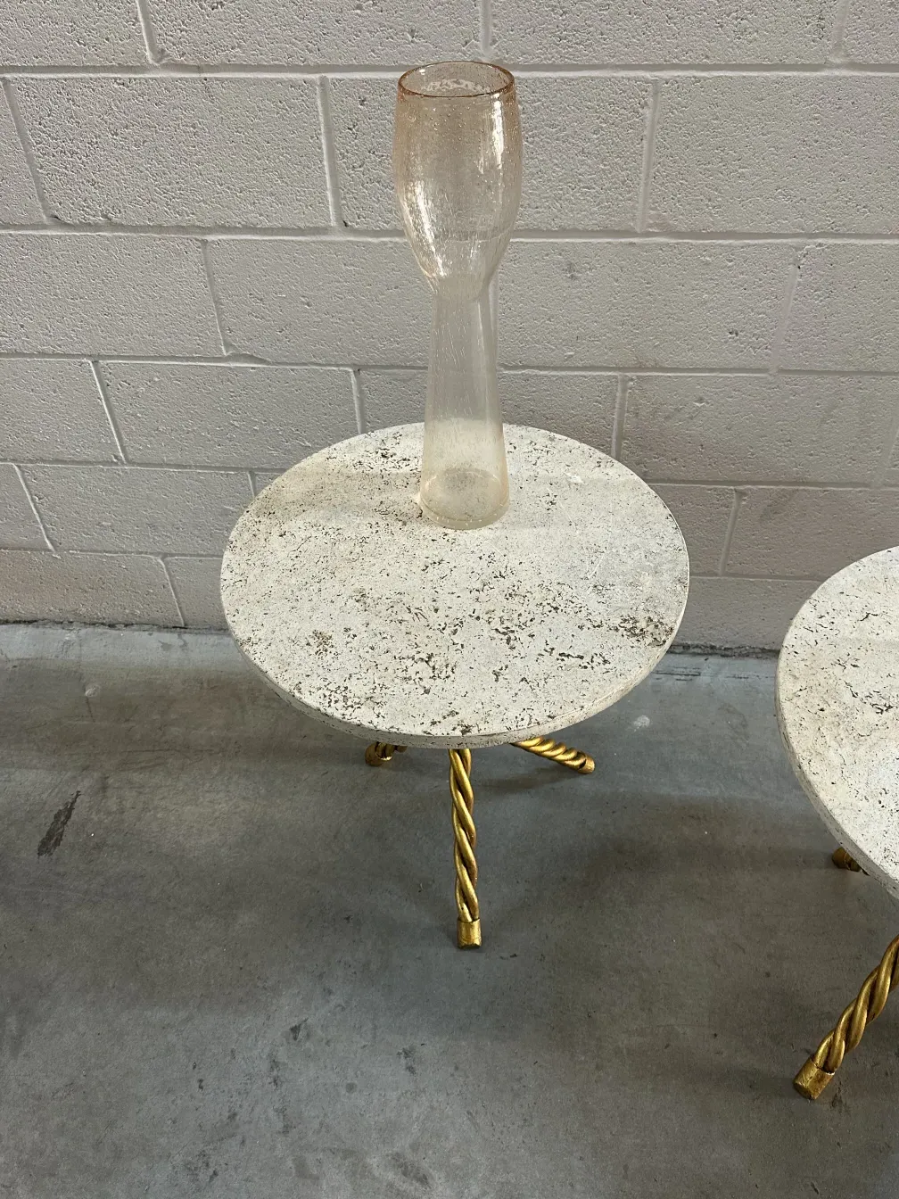 Deux petites tables anciennes avec des bases dorées dans un cadre neutre