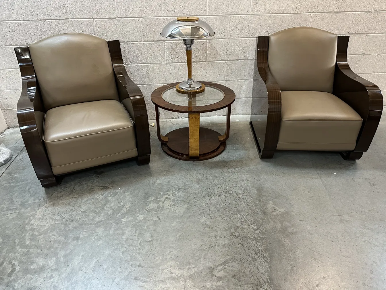 Two antique small tables flanked by armchairs in a warm environment.