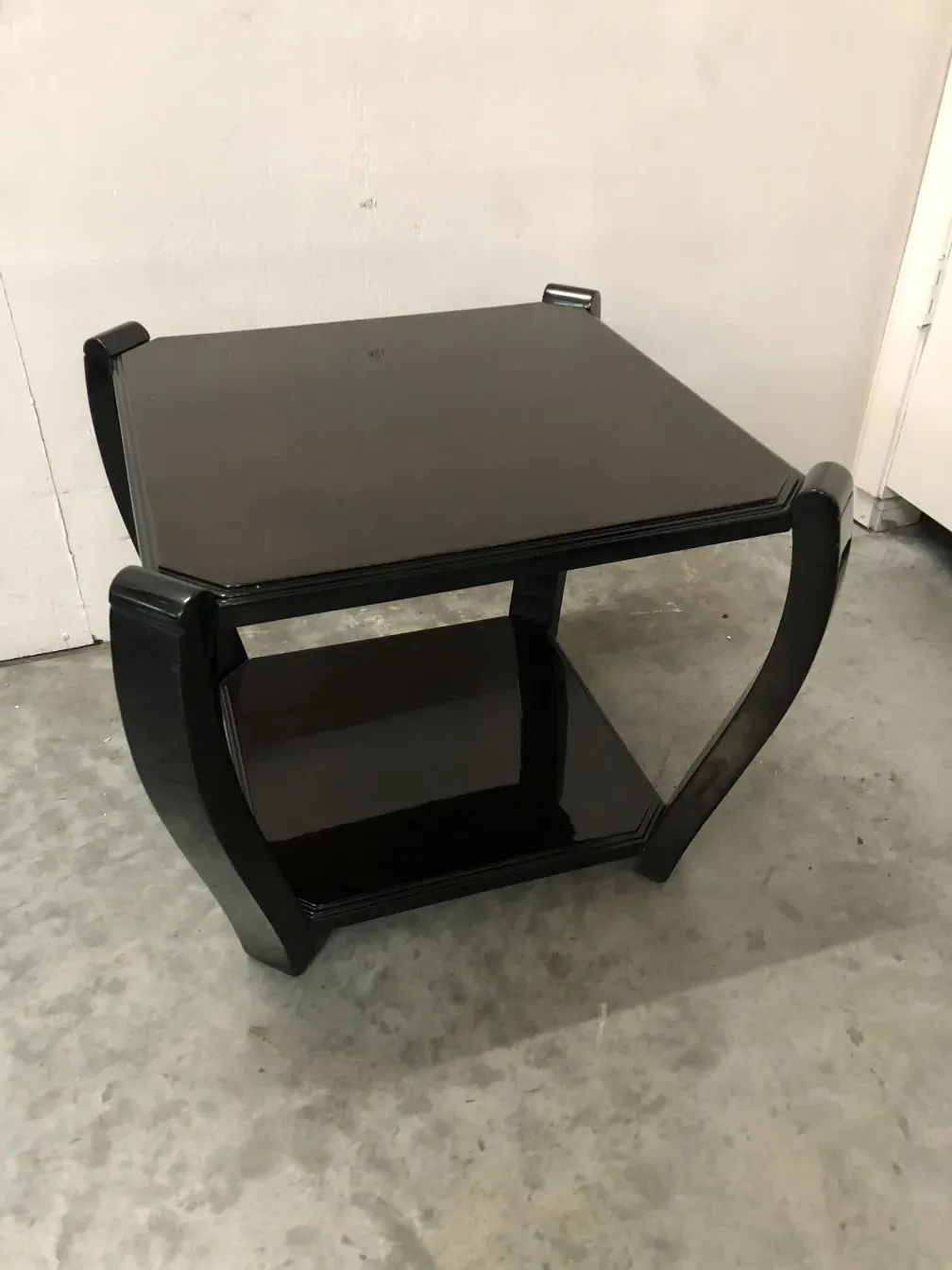 Due tavolini antichi con design elegante in un ambiente neutro.