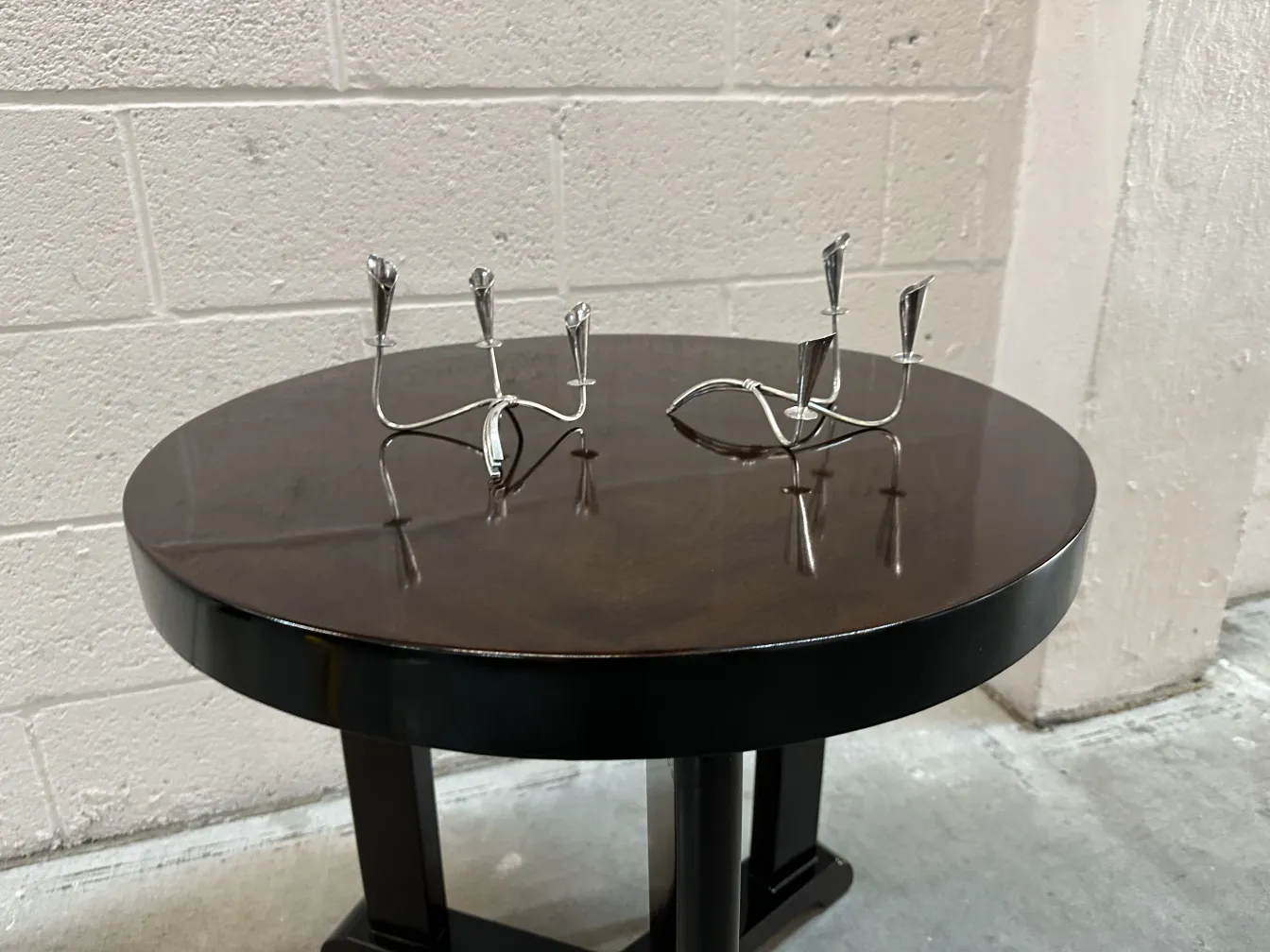 dois castiçais antigos em uma mesa escura com fundo simples