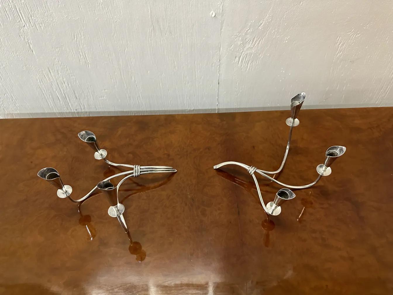 Set of 2 antique candelabras, featuring elegant shapes and decorative details, on a polished surface.