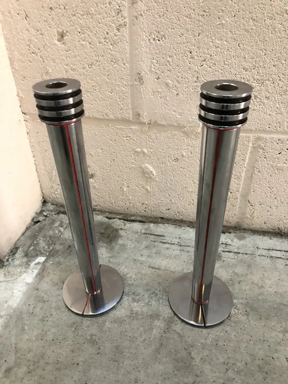 2 antike Kerzenhalter mit runder Basis in neutralem Umfeld