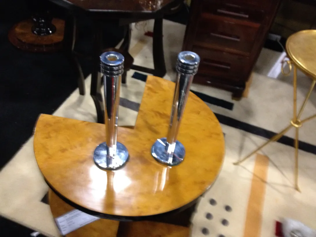 Zwei antike Kerzenhalter auf einem Tisch, variierter Hintergrund.