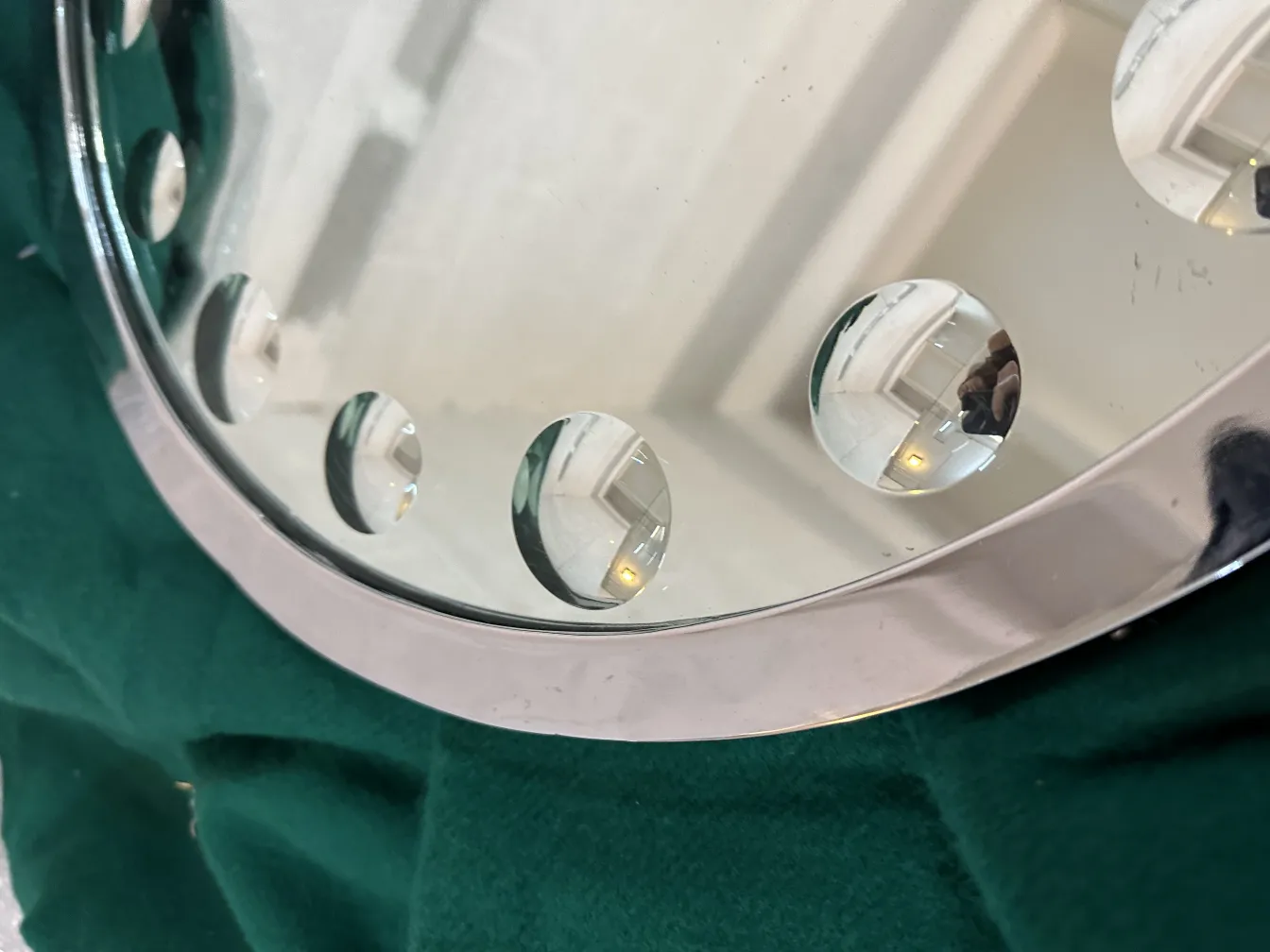 Specchio antico rotondo con dettagli di design sulla superficie.