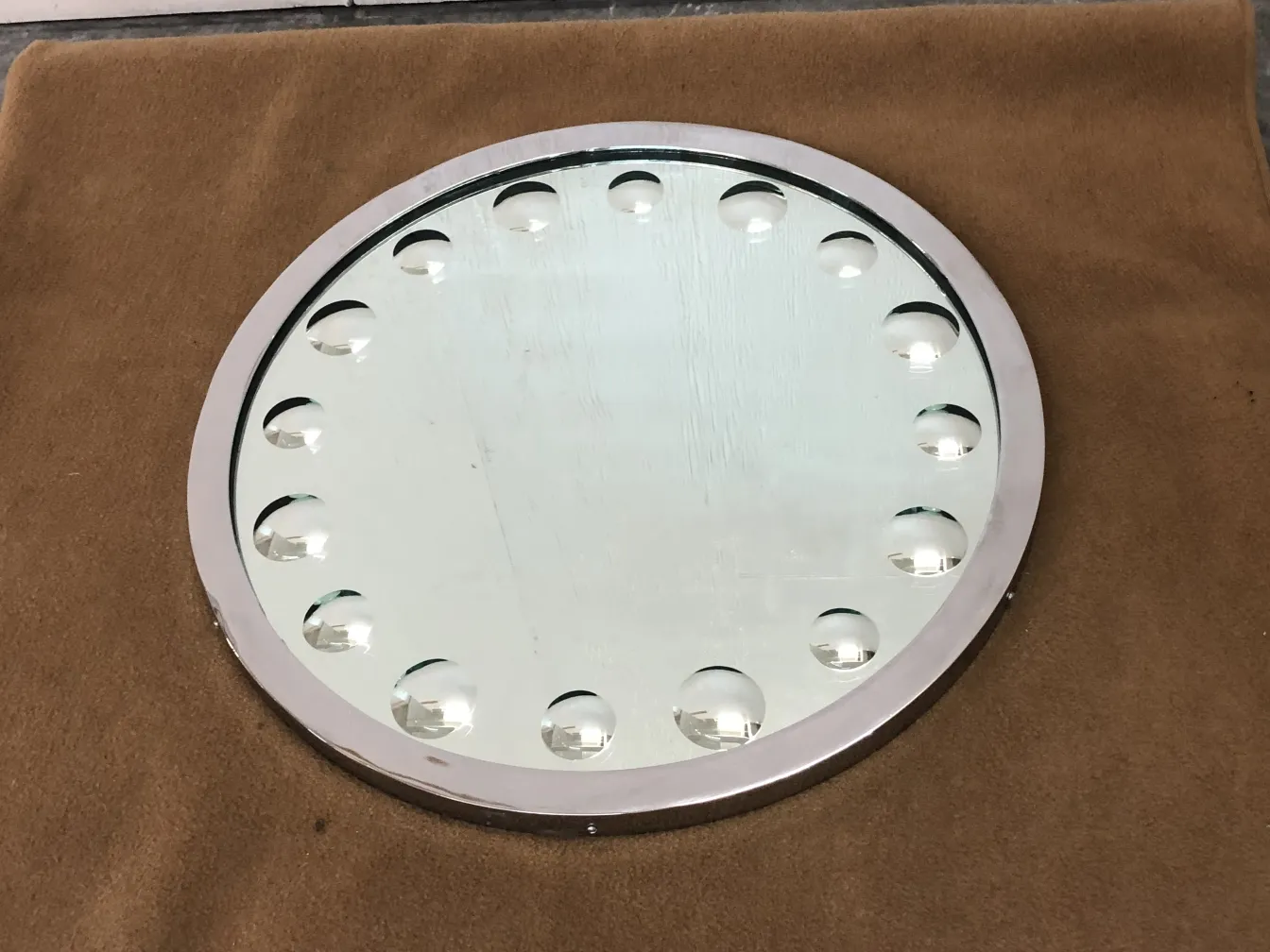 Miroir ancien rond avec des boules visibles sur le bord