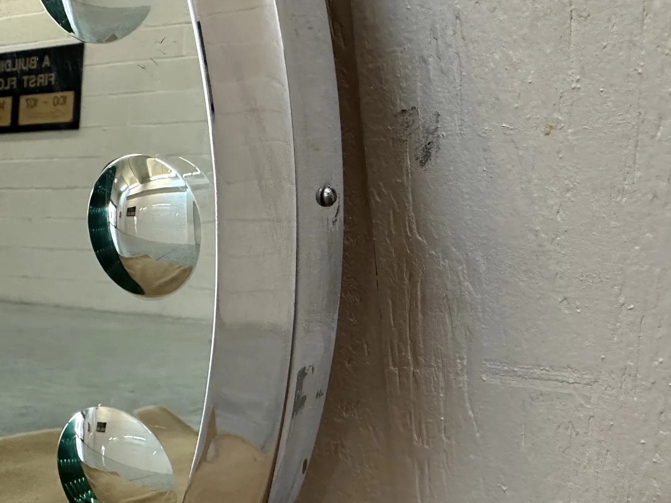 Miroir ancien avec un design circulaire et des reflets visibles.