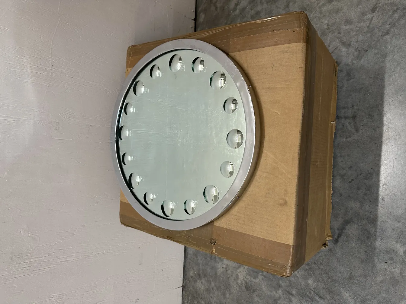 specchio antico rotondo con illuminazione, presentato