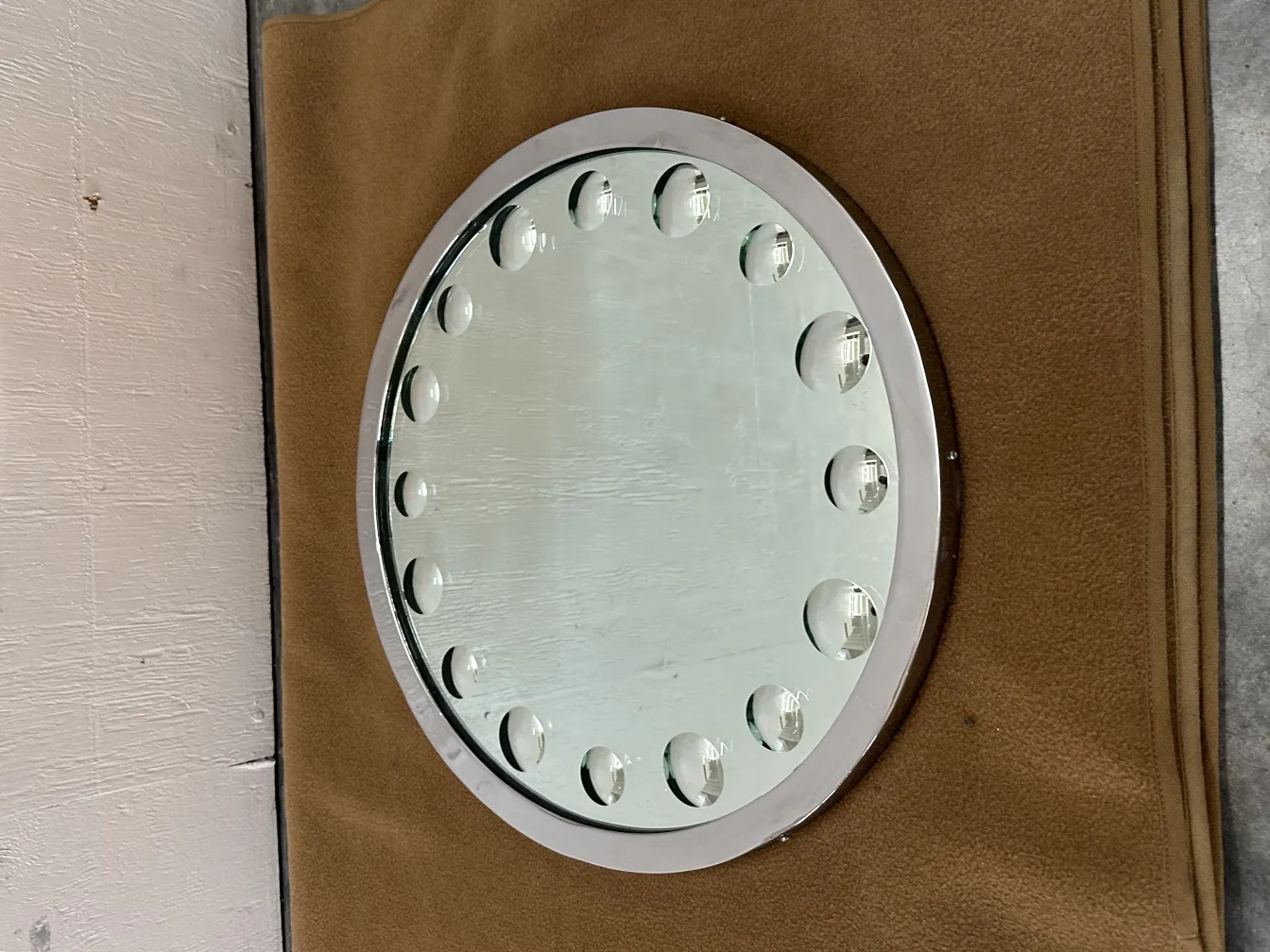 miroir antique avec bord arrondi et biseau dans un environnement neutre.