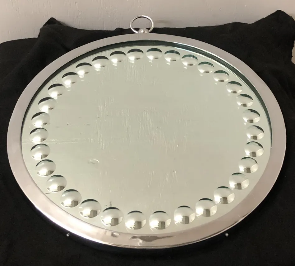 due specchi antichi rotondi con una cornice lucida e decorativa.