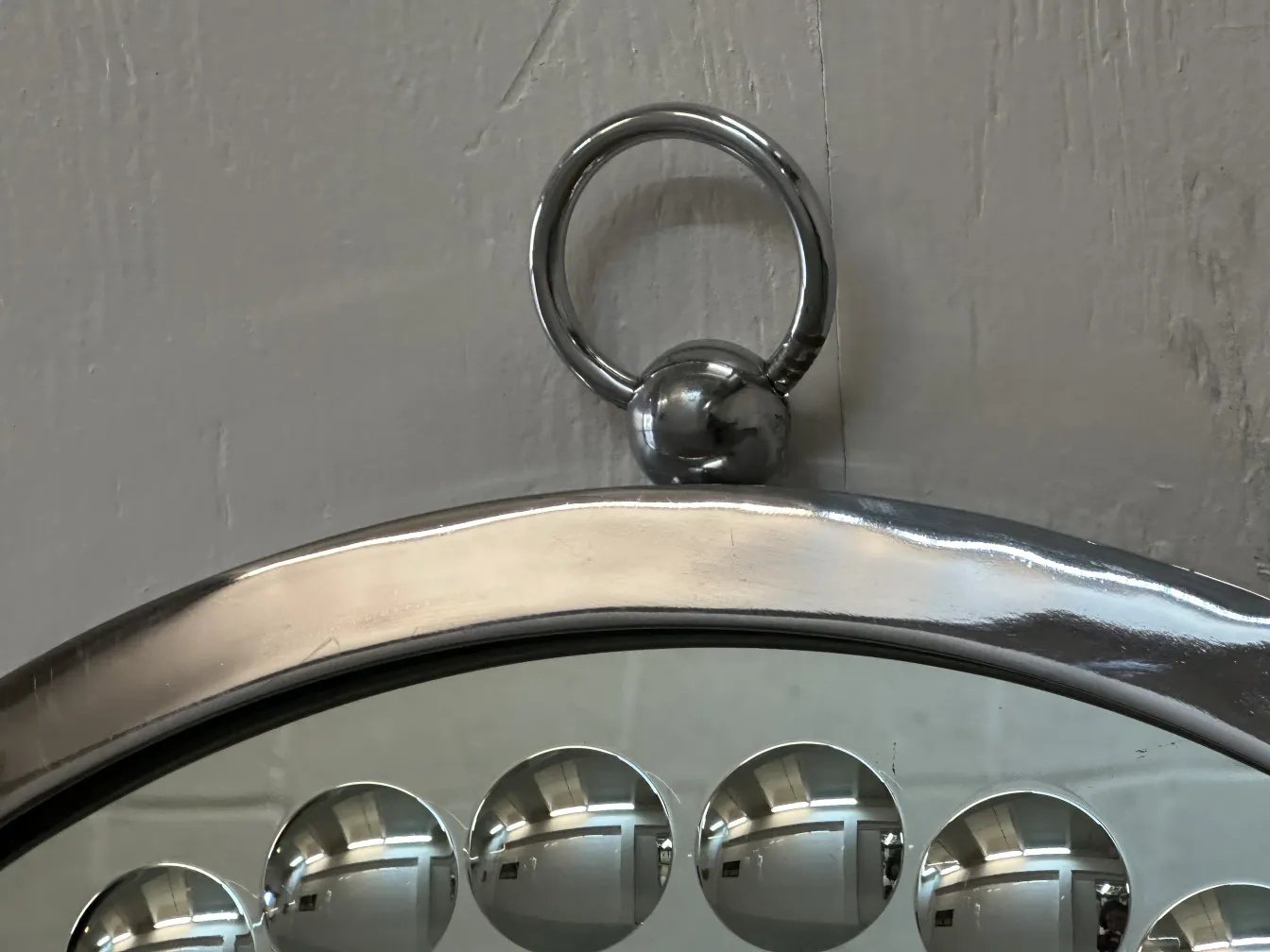 Zwei antike dekorative Spiegel mit gebogenem Rahmen und abgerundeten Details in einer neutralen Umgebung.