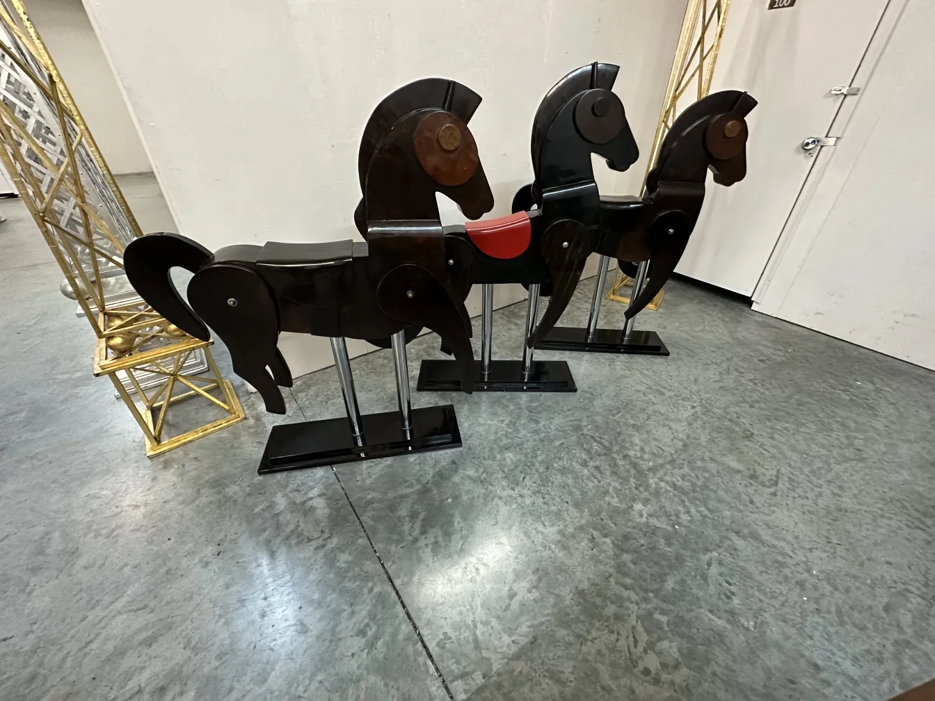 Escultura antiga de dois cavalos com detalhes na base.