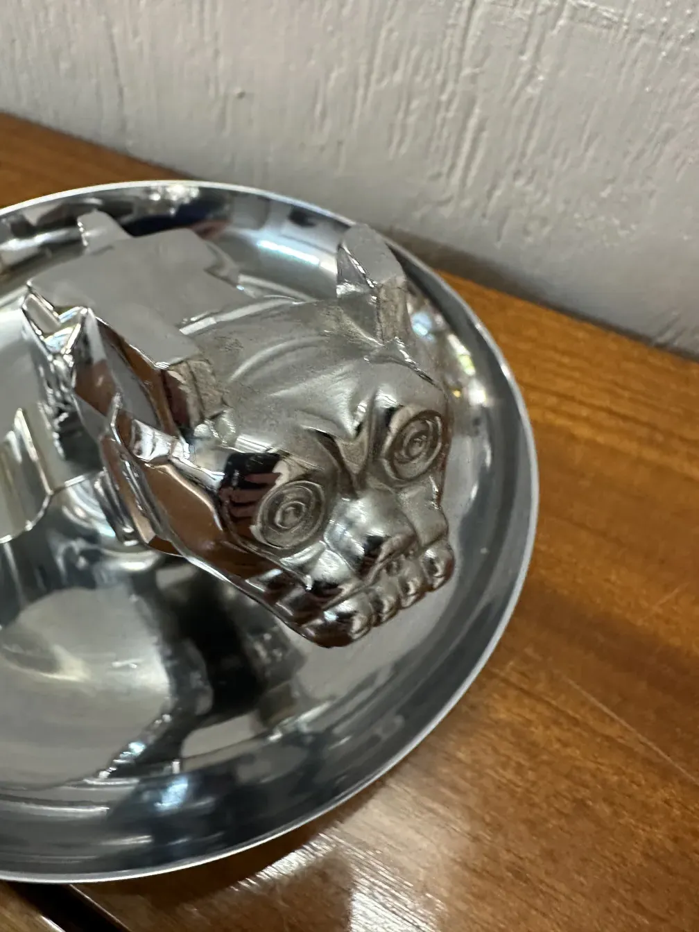 cenicero antiguo con diseño de cabeza, brillo metálico