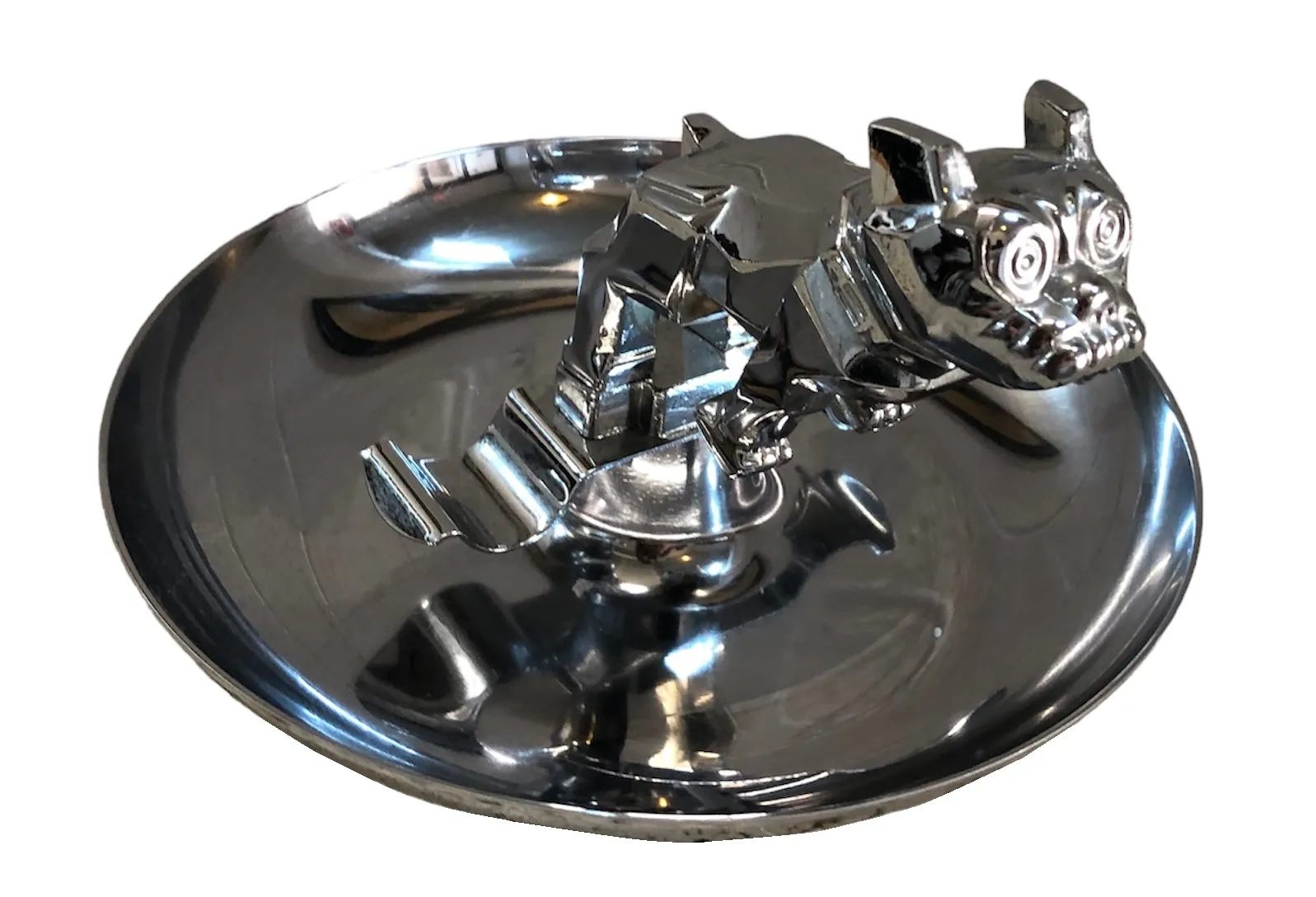 Cendrier ancien avec figurine de chien sur une surface brillante, parfait pour les collectionneurs.