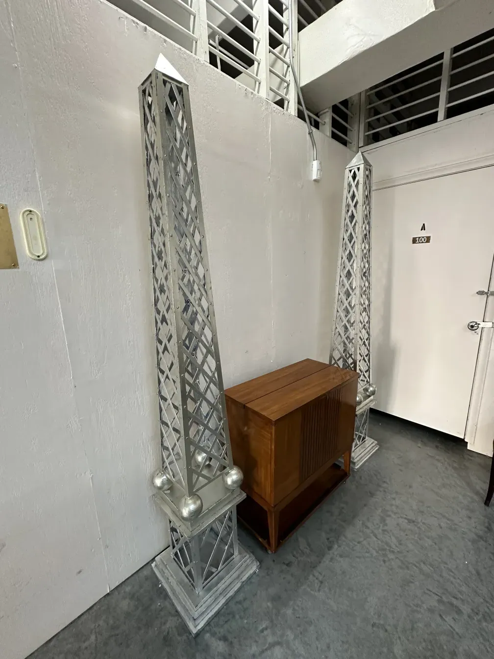 Meuble à cocktail ancien avec forme rectangulaire et détails décoratifs, entouré de colonnes ornementales.