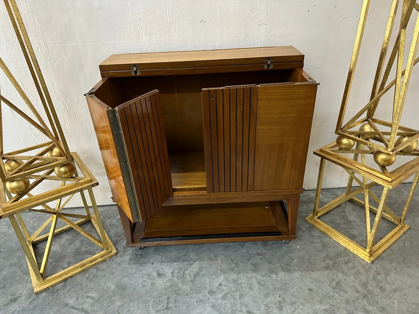 Móvel bar antigo com portas de madeira e elementos decorativos ao redor