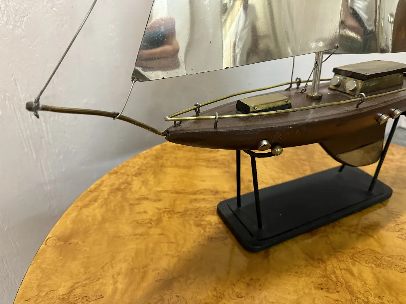 Modelo de barco antiguo con una vela y base de soporte.