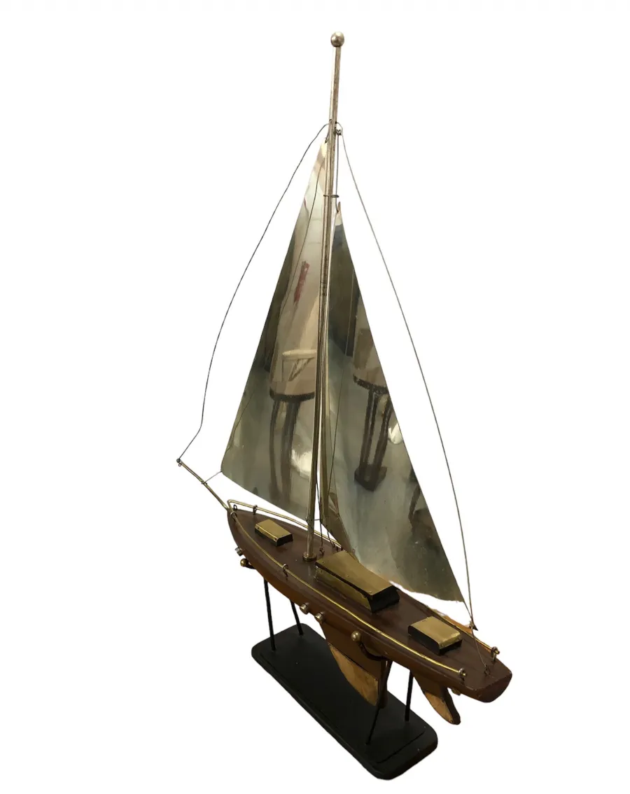 Antique designer's ship model with white sails and black base.