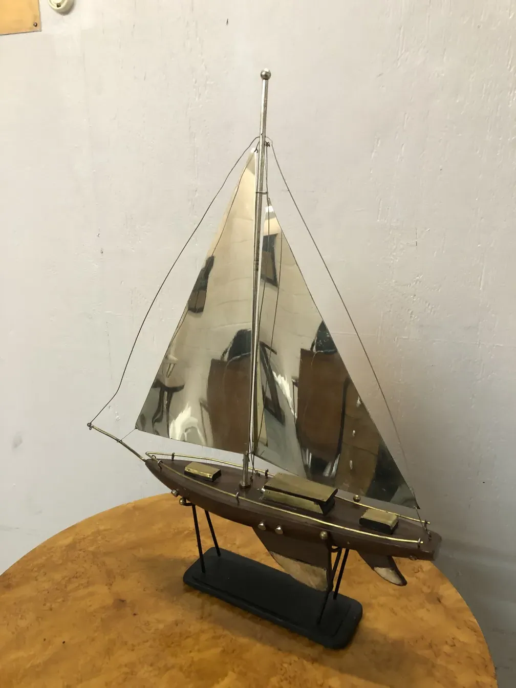 Modèle ancien de bateau du designer en échelle avec des voiles brillantes et des détails élégants sur fond neutre.