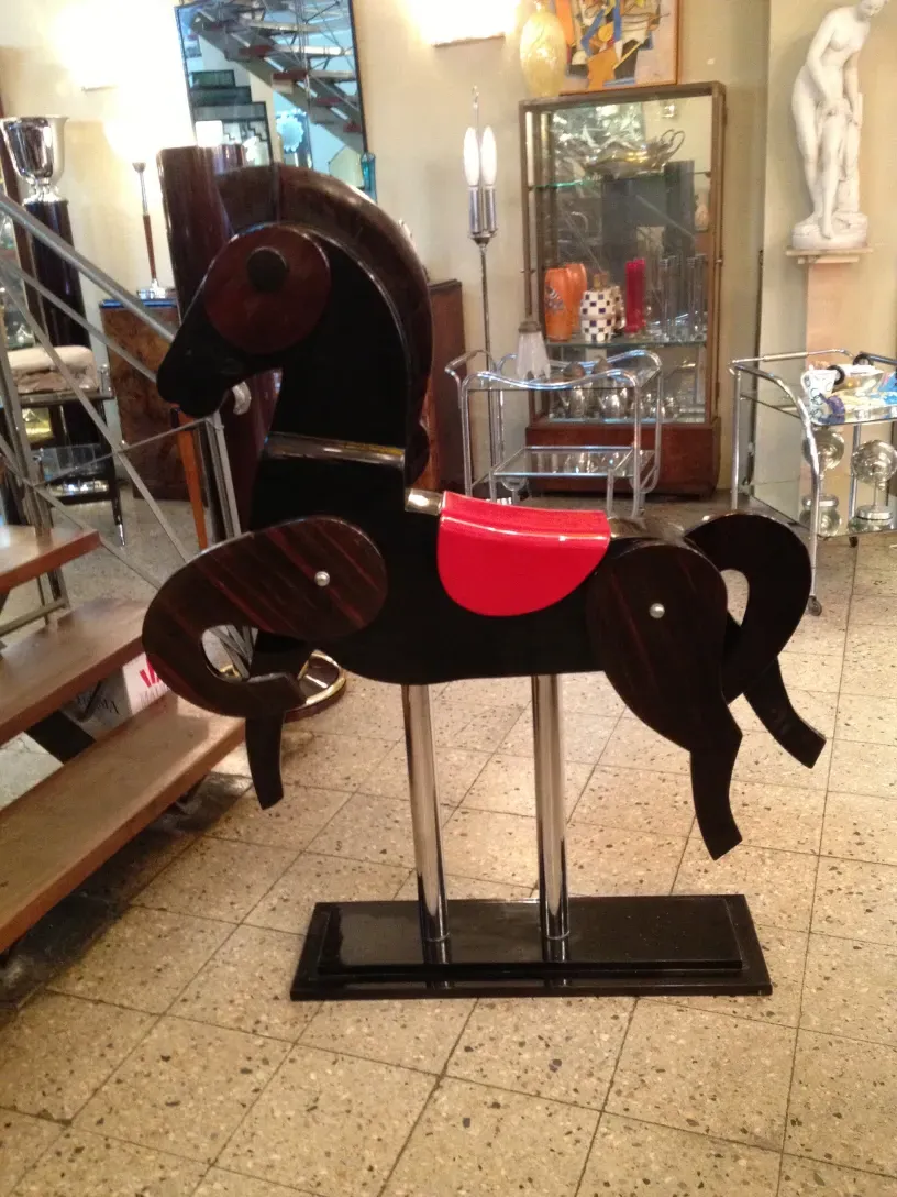 antico cavallo con sella rossa e base in metallo