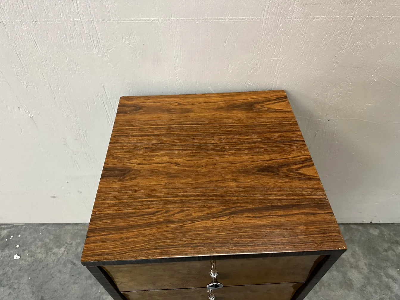 Top view of an antique cabinet with two drawers in a minimalistic environment.