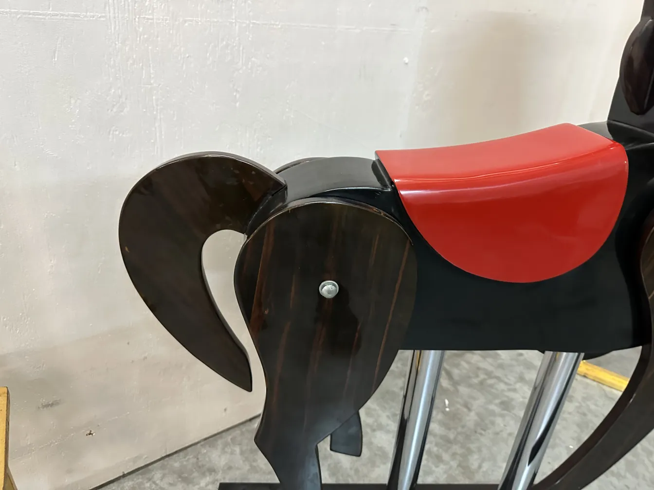 Scultura antica di cavallo con dettagli decorativi, sfondo neutro.