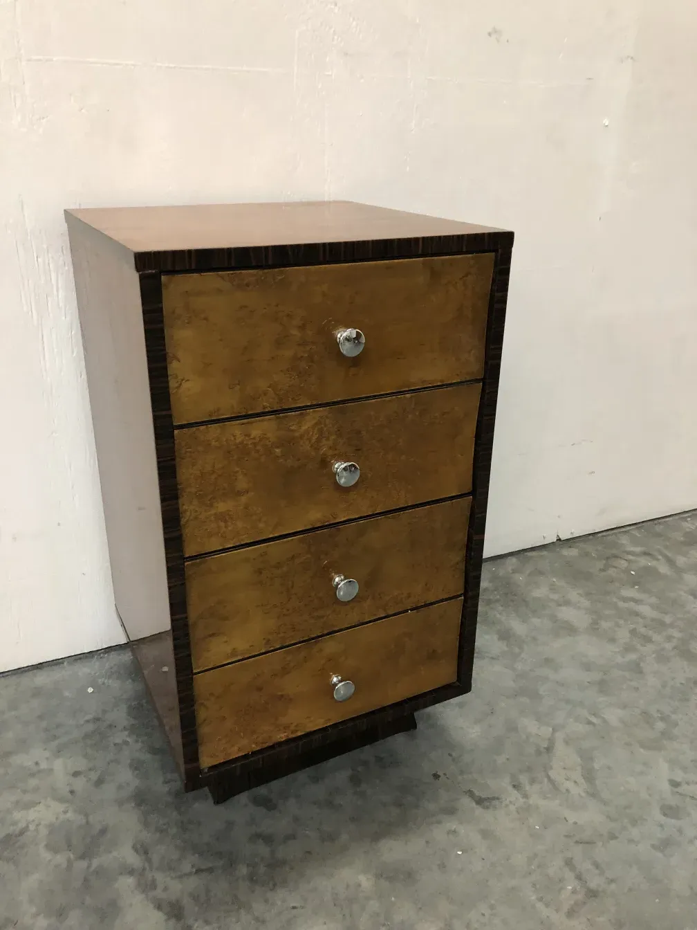 commode ancienne avec un design unique et quatre tiroirs dorés dans un cadre classique