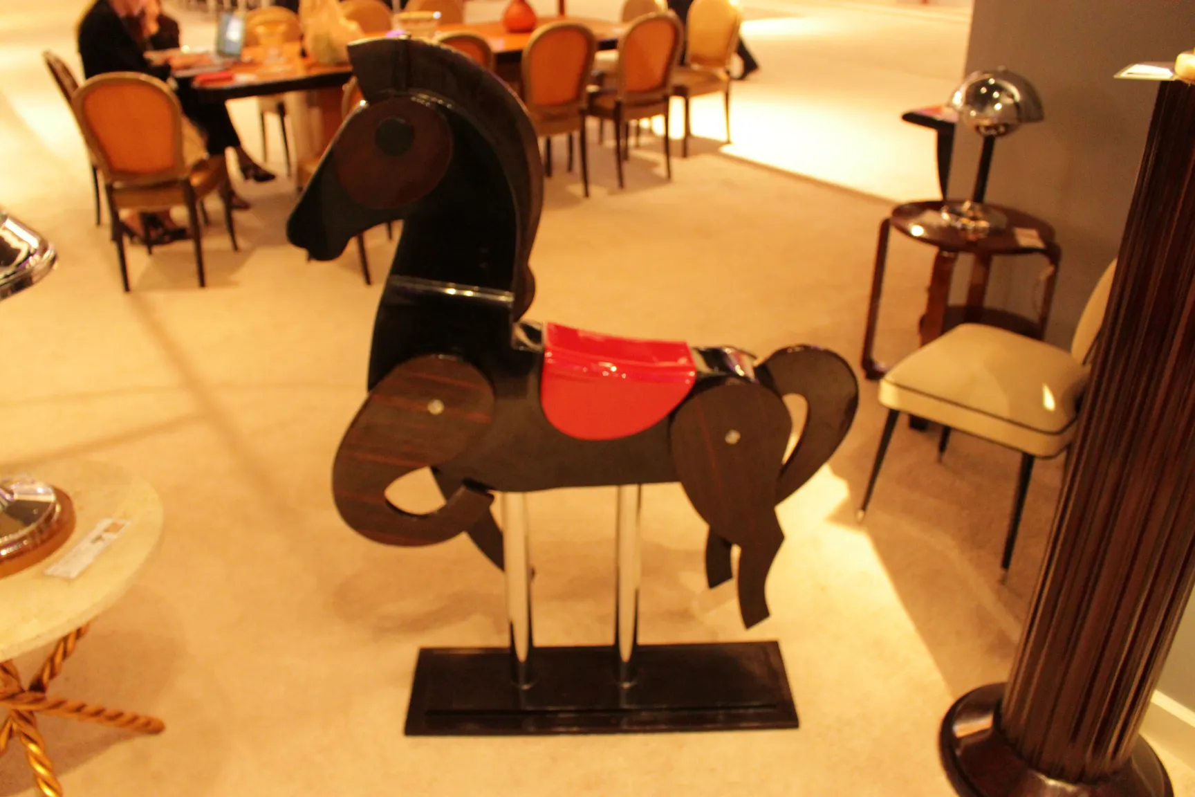 escultura antigua de caballo negra con silla roja