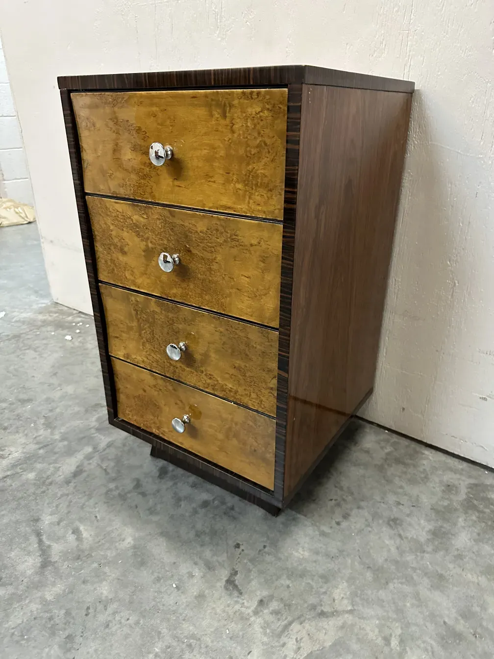 Cómoda antigua de cuatro drawers con acabados decorativos, ambiente de interior