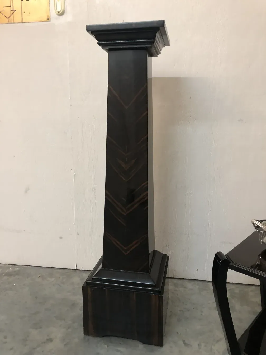 Colonne ancienne décorative avec un design élégant sur un fond clair.