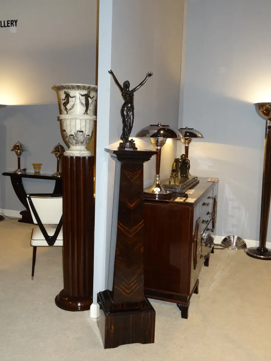 Coluna antiga decorativa com detalhes elaborados, ambiente elegante.