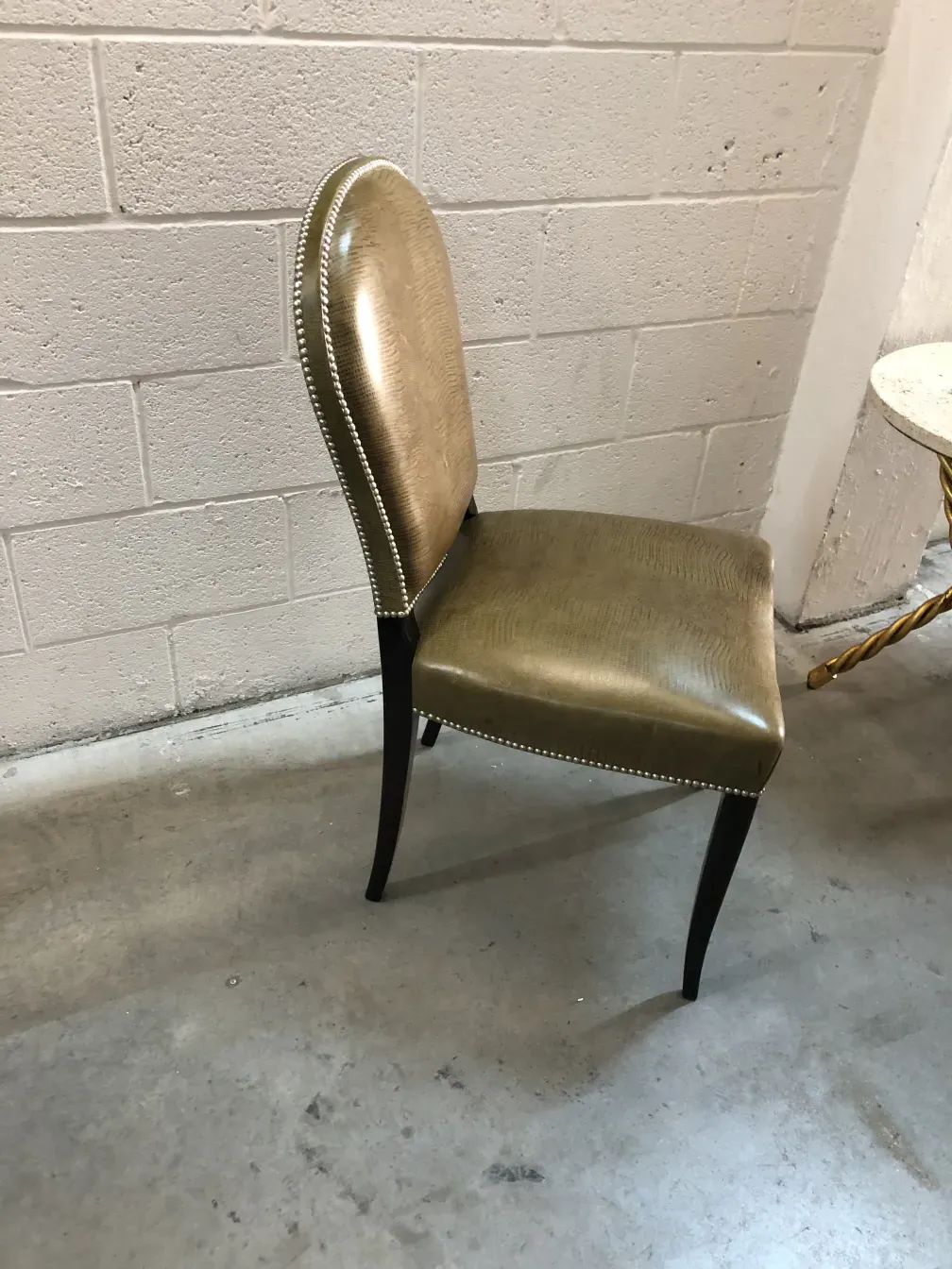 Ansicht eines eleganten goldenen antiken Stuhls mit klassischem Design und neutralem Hintergrund.