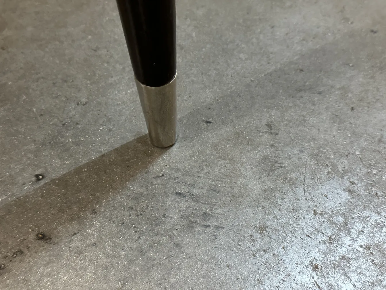 Ansicht der Basis eines antiken Stuhls mit Detail des Metallfußes.