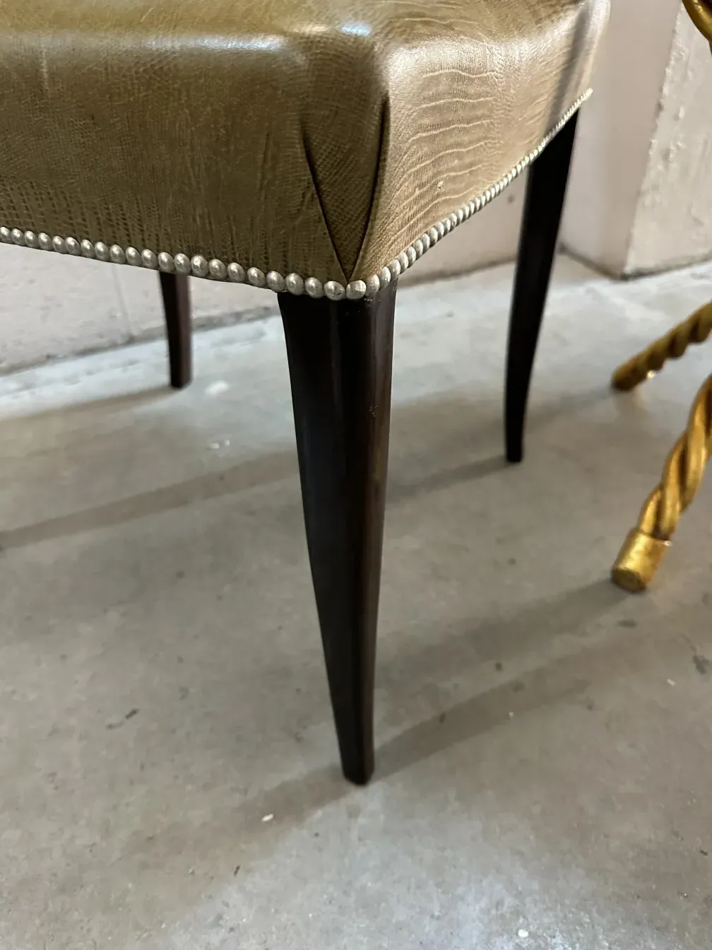 Visão lateral de cadeiras antigas com design refinado e pernas elegantes em um ambiente moderno.