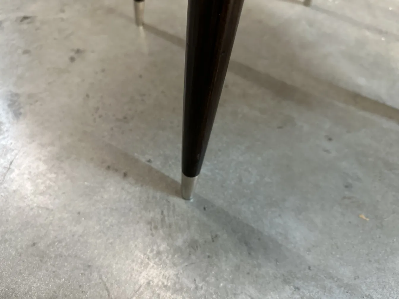 Close-up of an antique chair leg with elegant detail, belonging to carlo mollino.