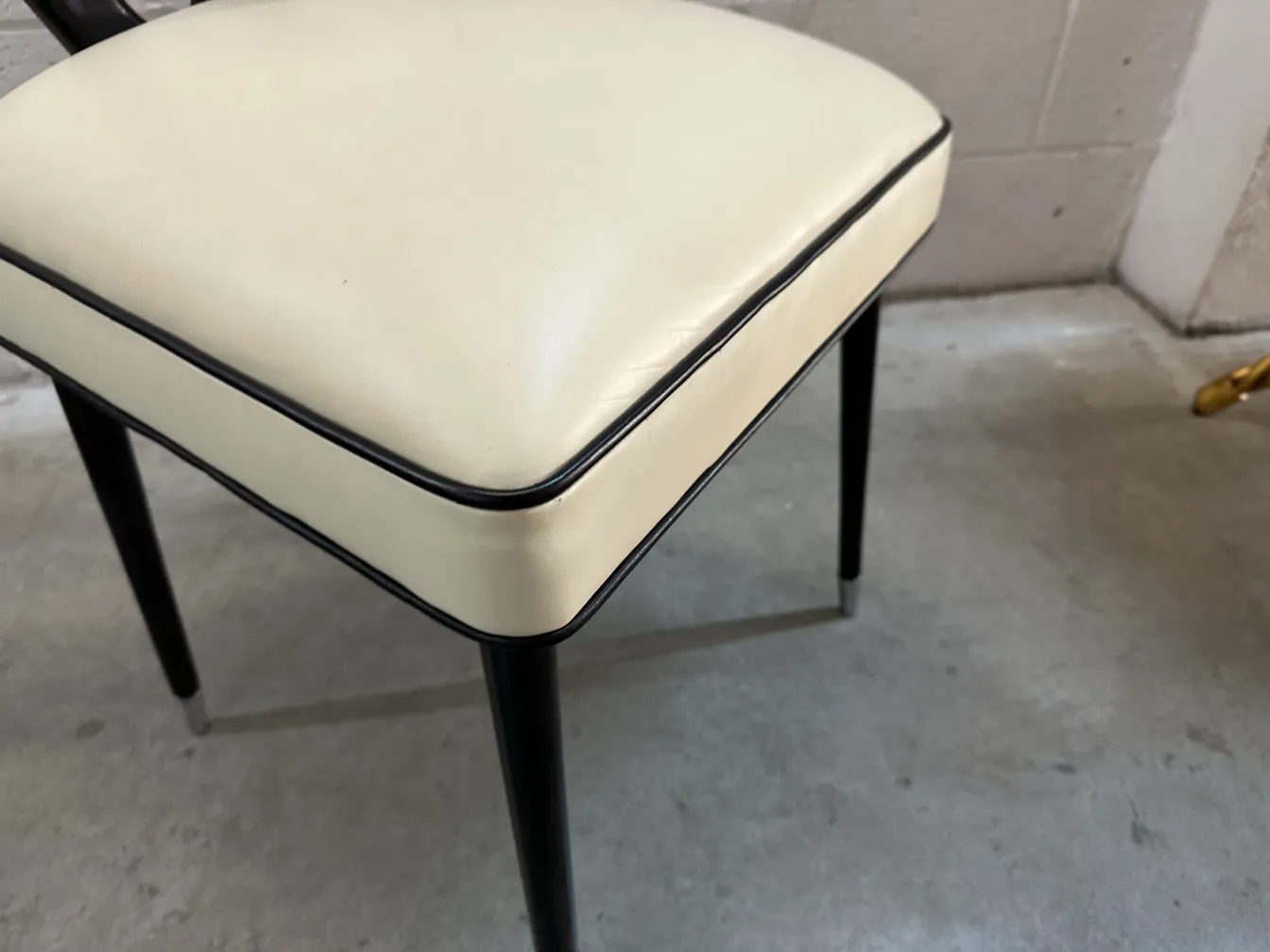 2 chaises anciennes avec coussins clairs et pieds foncés dans un cadre sobre